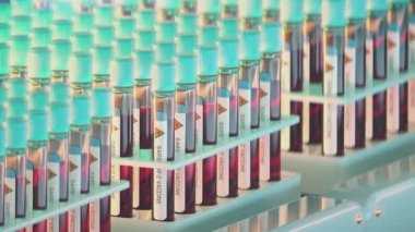Konveyör bandında koronavirüs aşısı olan numune test tüplerinin yakın çekimleri
