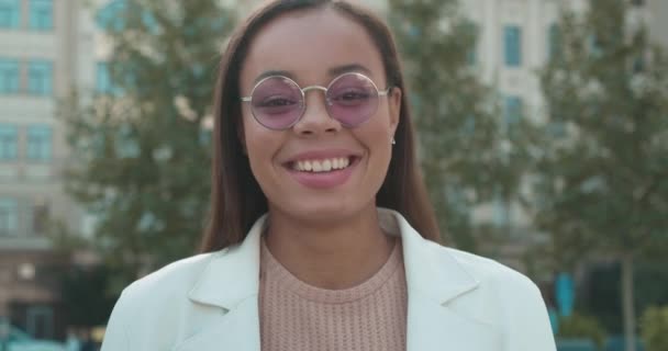 Happy african female taking pink eyeglasses off, winking on camera, fashion — Stock Video