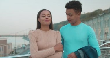 Sevgi dolu bir adam kız arkadaşıyla ilgileniyor, omuzlarına ceket giyiyor, şefkat gösteriyor.