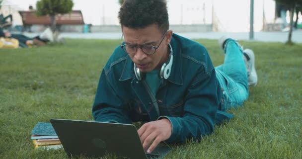 Soustředěný mladý muž hledající informace, psaní na notebooku, chytrý student — Stock video