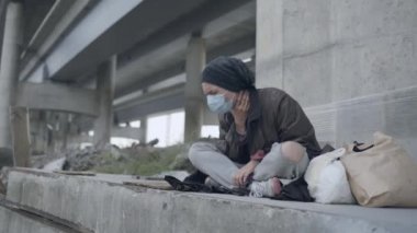 Koruyucu maskeli hasta kadın dışarıda öksürüyor, nefes darlığı, soluk soluğa.