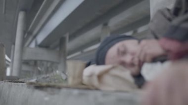 Mülteci dilenci bardağının yanında uyuyor, yerde yatıyor, sosyal dışlanma.