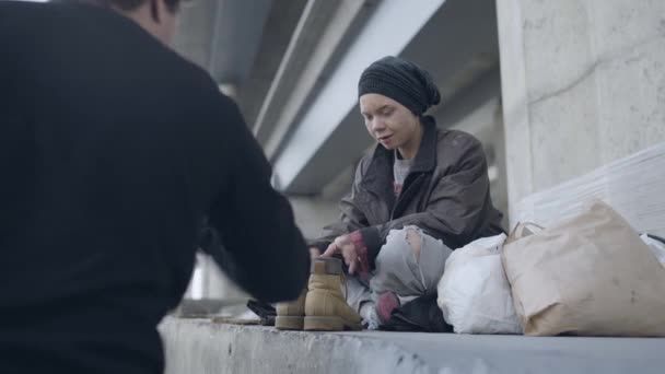 노숙자들에게 신발을 기부하는 남성 자원 봉사자, 거리에 살고 있는 자선 단체 — 비디오