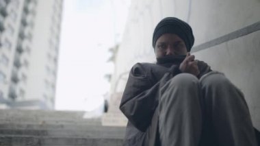 Ümitsiz zavallı kadın üşüyor, merdivenlerde oturuyor, sosyal dışlanıyor.