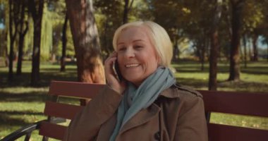 Gülümseyen kadın haberlerini akıllı telefondan, cep telefonu planından, uygulamadan aktarıyor.