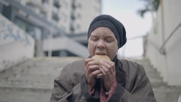 Honger arme vrouw eet fast food sandwich, basisbehoeften van daklozen — Stockvideo