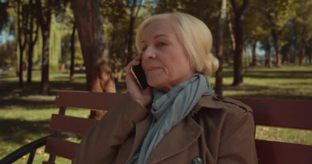Szomorú nyugdíjas nő veszi fel a telefont, rossz híreket kap, sokkoló információkat kap. — Stock videók