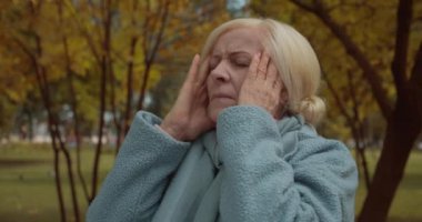 Yaşlı kadın migren, yüksek tansiyon ve şiddetli baş ağrısı çekiyor.