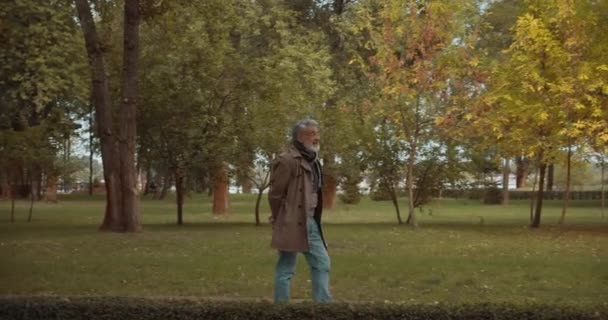 Stylový starší muž procházející se v parku, užívající si volného času, aktivní důchodce, odpočinek — Stock video