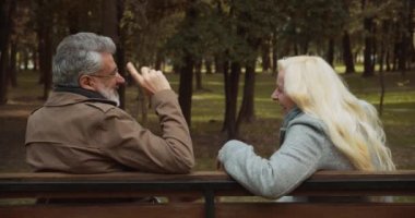 Mutlu çift gülüyor, mutlu anları tartışıyor, kadın ve erkek parkta flört ediyor.