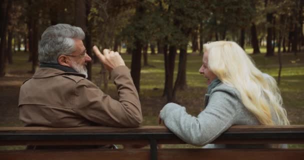 Счастливая пара смеется, обсуждая счастливые моменты, мужчина и женщина флиртуют в парке — стоковое видео