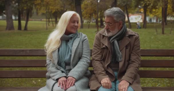 Tímida pareja de ancianos cogidos de la mano, cita romántica en el parque, sentimientos tiernos, coquetear — Vídeo de stock