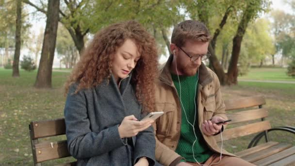 Namorado e namorada ouvindo música juntos por aplicativo de telefone, geração — Vídeo de Stock