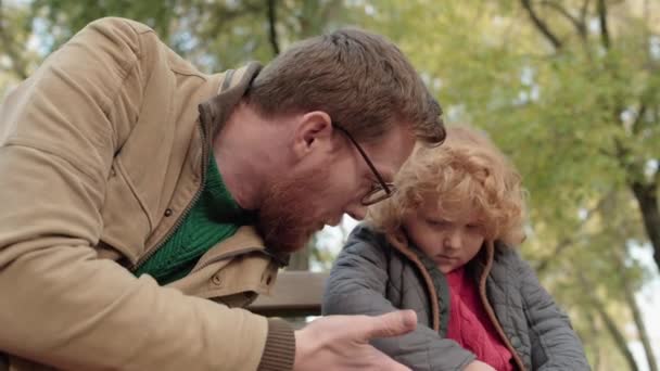 Otec mluví s uraženým synem v parku, chování dítěte, rodičovská podpora — Stock video