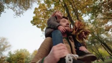 Baba ve oğul sonbahar parkında yürüyorlar, birlikte zaman geçiriyorlar, büyüyorlar.