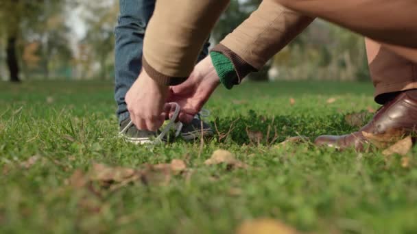 Padre atando los cordones de los zapatos del hijo, cuidando del niño, feliz paternidad, crianza — Vídeos de Stock