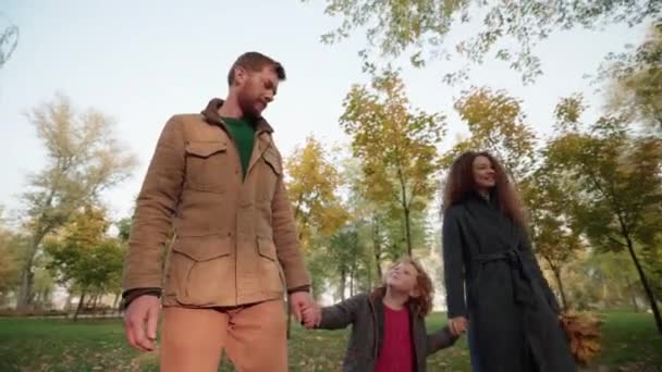 秋の公園を歩く幸せな若い両親と子供、家族の愛、一緒に — ストック動画