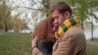 Değer veren erkek arkadaş parkta kız arkadaşına sarılıyor, aşık genç bir çift, sevgi