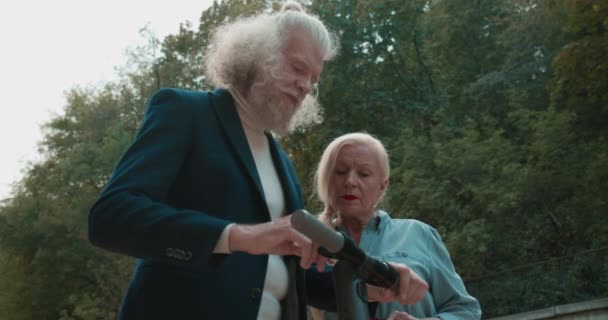 トレンディは妻に電動スクーターの使い方を説明する退職者をひげそり — ストック動画