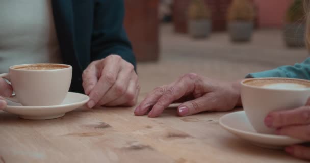 Bărbat în vârstă care ia mâna soției, cuplu care bea cafea în cafenea în aer liber, sprijin — Videoclip de stoc