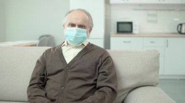 Kıdemli erkek kameraya bakıyor, kollarını kavuşturuyor, koruyucu önlemler, sağlık