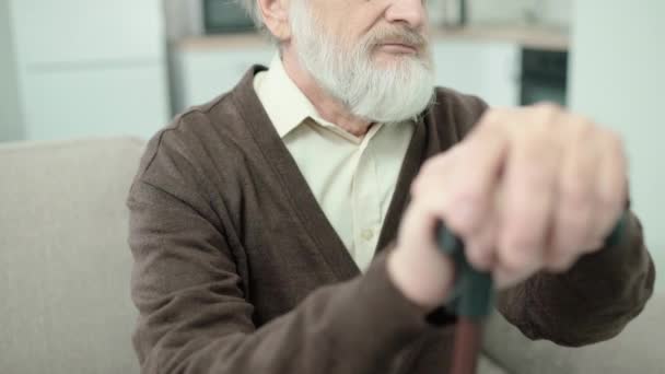Pensionista de pelo gris infeliz sentirse solo, apoyándose en bastón, enfermedad — Vídeos de Stock