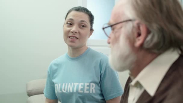 Lachende maatschappelijk werker communiceert met gepensioneerde, ouderenzorg vrijwilligerswerk — Stockvideo