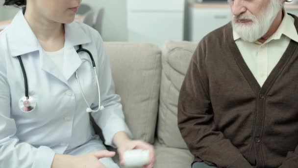 Γυναίκα γιατρός δίνει χάπια σε ηλικιωμένους άνδρες, θεραπεία ασθενειών, υγειονομική περίθαλψη — Αρχείο Βίντεο