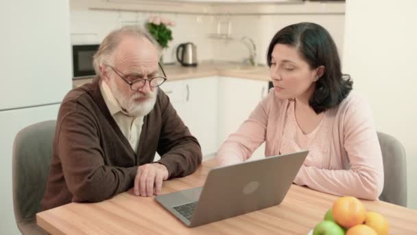 Putri menjelaskan kepada ayah yang sudah tua bagaimana menggunakan laptop, online banking, bantuan — Stok Video