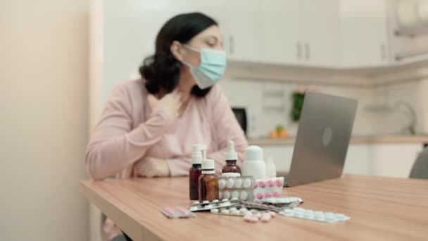 Kranke Frau in Maske spricht online mit Arzt, verschriebene Medikamente auf dem Tisch — Stockvideo