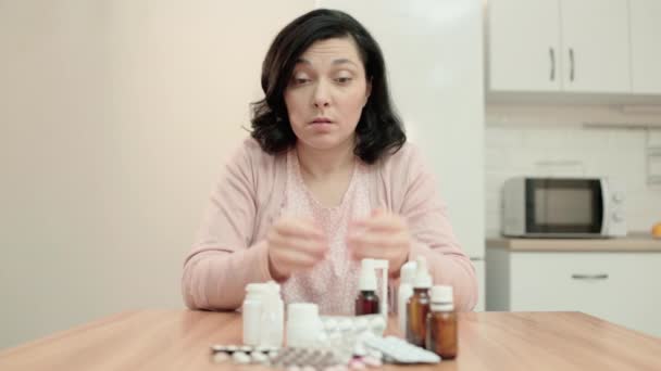 Upprörd kvinna tittar på medicinering på bordet, dyr behandling, försäkring — Stockvideo