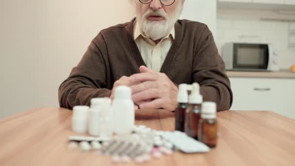 Olycklig sjuk pensionär tittar på piller, dyr behandling, övermedicinering — Stockvideo