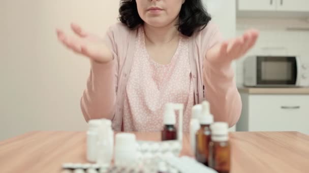 Mulher desesperada sentada na frente de comprimidos bolhas na mesa em casa, tratamento — Vídeo de Stock
