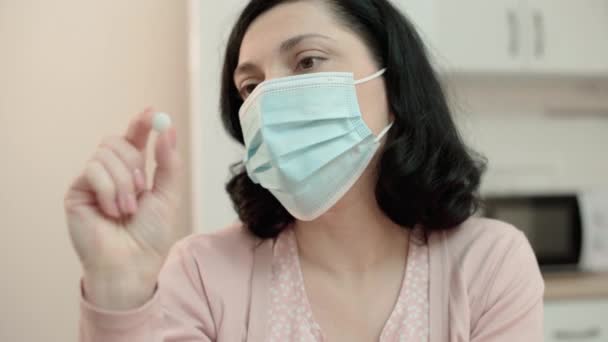 Žena v masce drží pilulky, antimedikace zaujatost, nedůvěra v koronavirus — Stock video