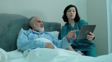 Doktor hasta analizine tablet, modern teknoloji ve klinik sonuçlarını gösteriyor.
