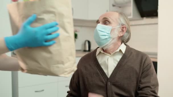Betagter Mann in Maske entwendet Einkaufstasche von freiwilliger Helferin, Charity-Projekt — Stockvideo