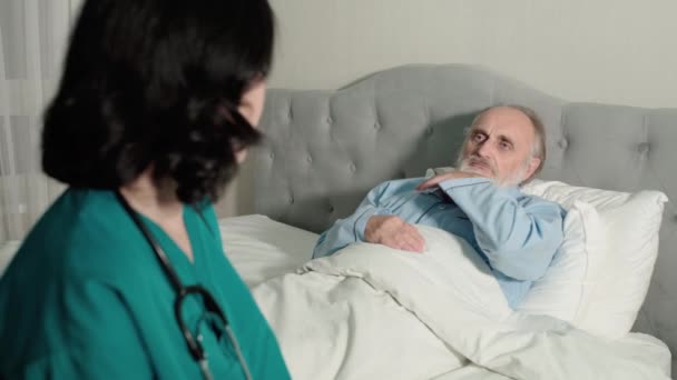 चिंतित देखभालकर्ता रोगी का तापमान ले रहा है, नर्सिंग होम केयर, स्वास्थ्य — स्टॉक वीडियो
