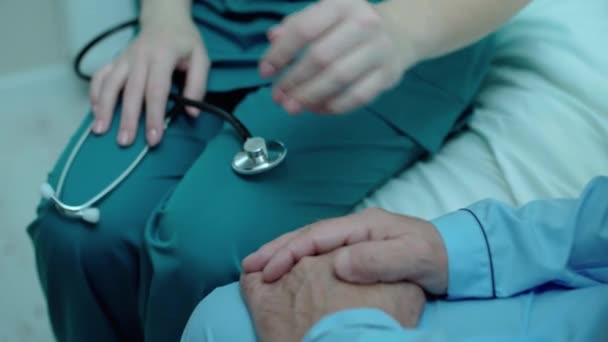 Ärztin unterstützt betagte Patientin im Krankenhaus, streichelt männliche Hand, pflegt — Stockvideo