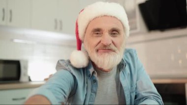 Noel Baba şapkalı gülümseyen olgun bir adam çocuklarla internetten iletişim kuruyor, aile bakımı...