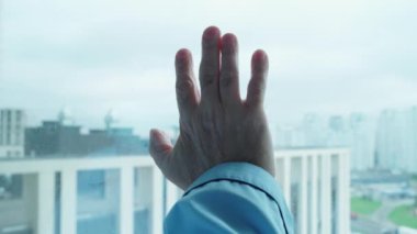 Maskeli düşünceli emekli hastane penceresinin yanında duruyor, koronavirüs salgını.