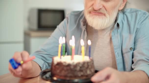 Sad grandfather blowing into party horn, celebrating birthday alone, pension — Stock Video