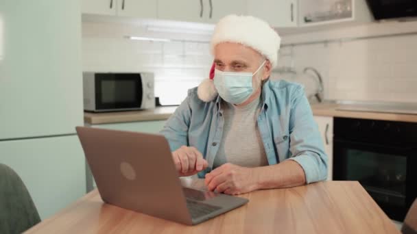 Homem aposentado em máscara comunicando on-line, férias em família durante a quarentena — Vídeo de Stock