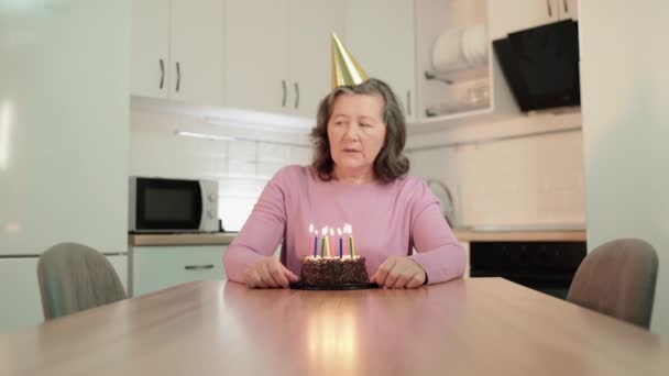Verärgerte Großmutter mit Partyhut vermisst Familie, feiert Geburtstag allein, altert — Stockvideo