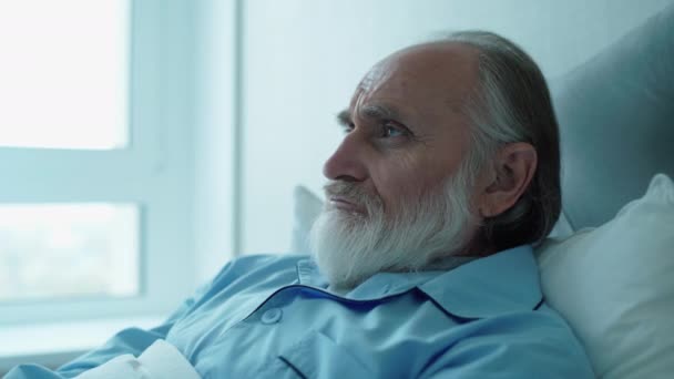 Deprimovaný dospělý muž ležící v posteli, rehabilitace v nemocnici, zdravotní péče — Stock video