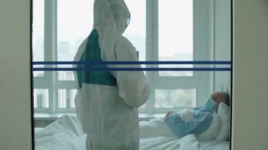 Maskeli bir hastayla konuşan sağlık çalışanı, klinikte koronavirüs tedavisi