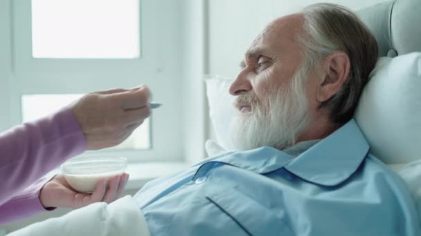 Žena krmení starší pacient v nemocnici, péče o seniory, pečovatelská služba doma — Stock video