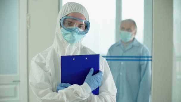 Медсестра в масці, дивлячись на камеру, медичний працівник під час пандемії ковадла-19 — стокове відео