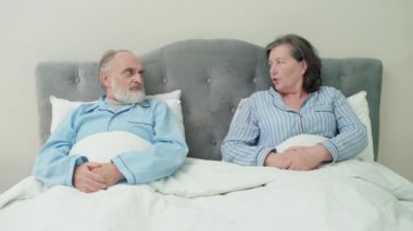 Yaşlı adam ve kadın yatakta tartışıyor, çift yanlış anlaması, aile krizi