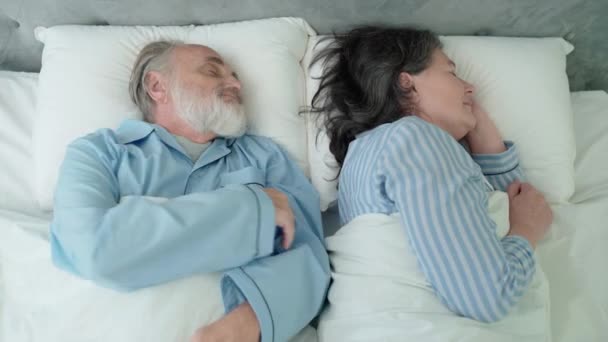 Pensionista de edad avanzada abrazando esposa, durmiendo juntos en la cama, tierna relación — Vídeos de Stock