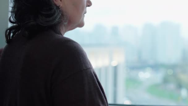白发苍苍的男人抚慰悲伤的妻子，站在窗前，心连心 — 图库视频影像